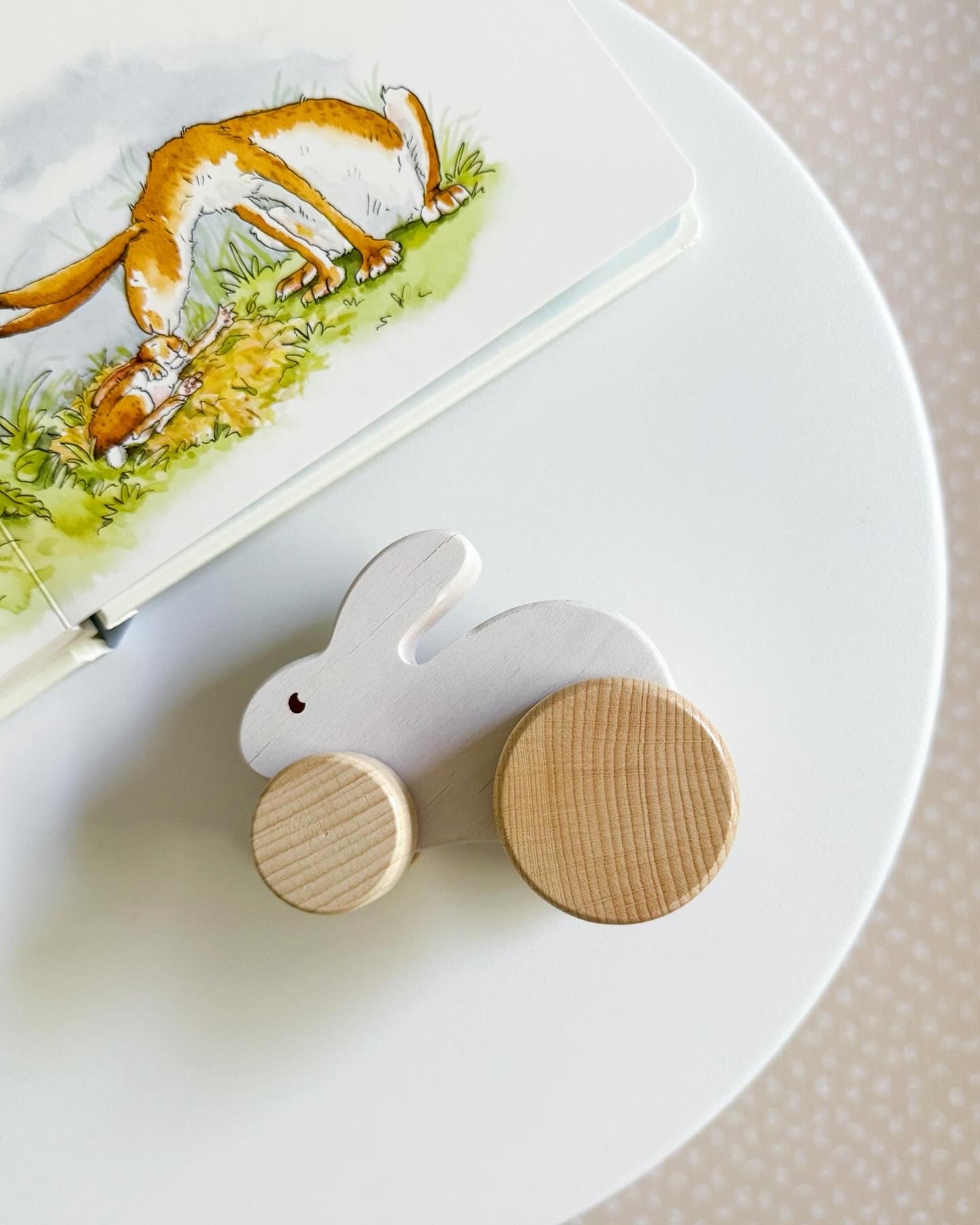 White wooden rabbit car sitting on a white side table